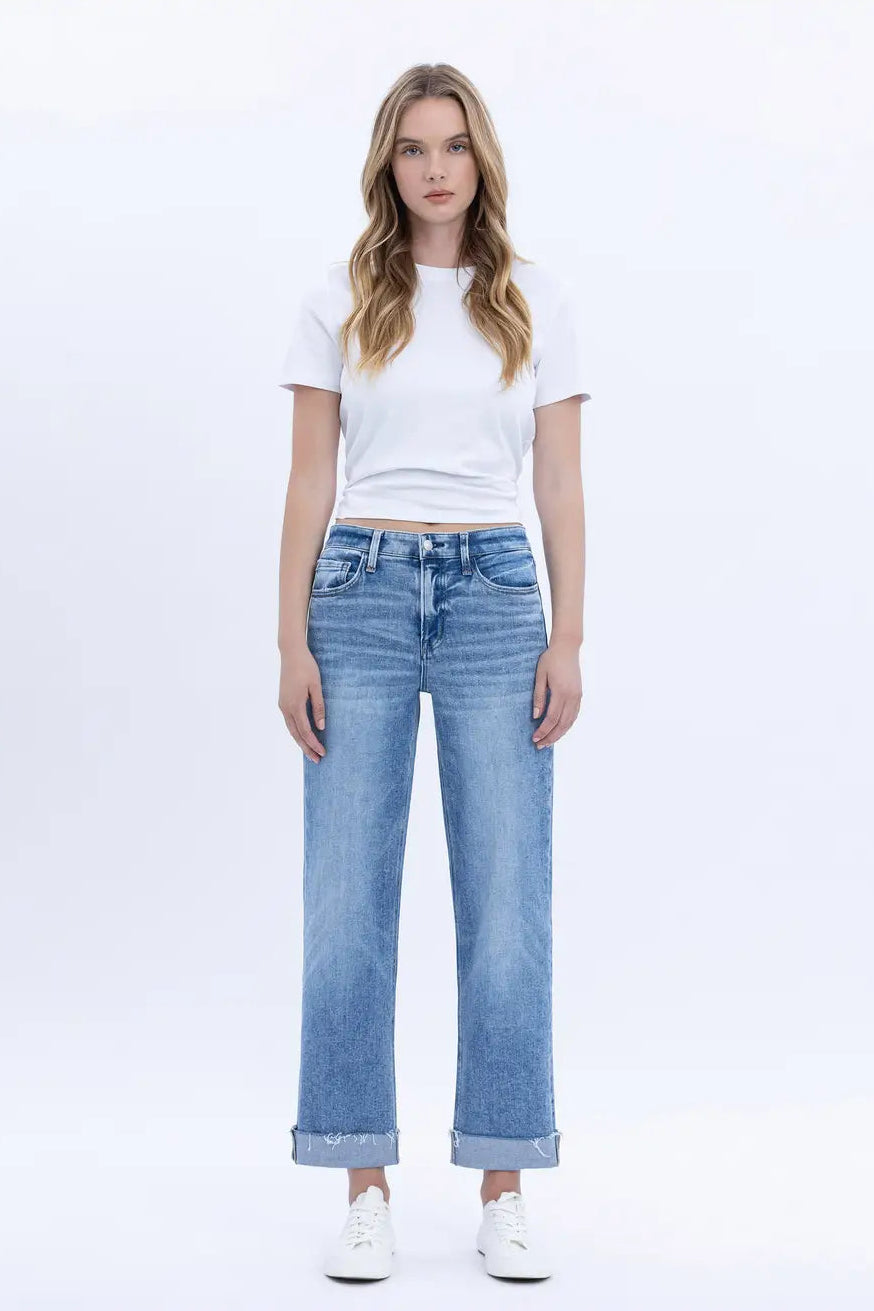 Woman wearing a white t-shirt and light blue jeans on a white background