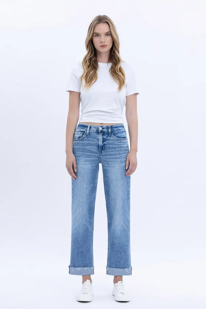 Woman wearing a white t-shirt and light blue jeans on a white background