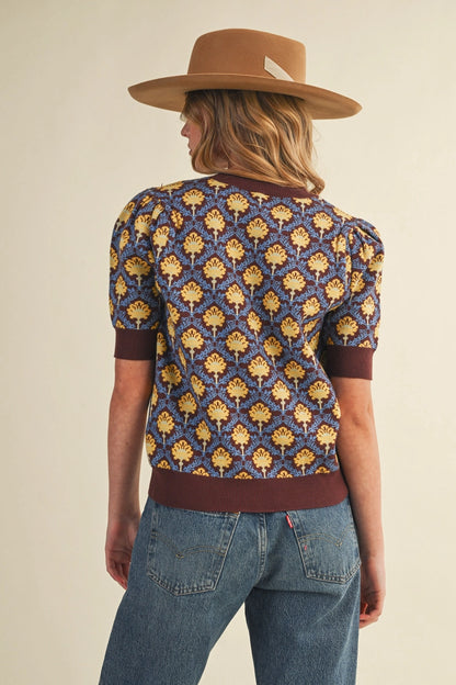 back view of woman in short sleeve floral sweater and jeans