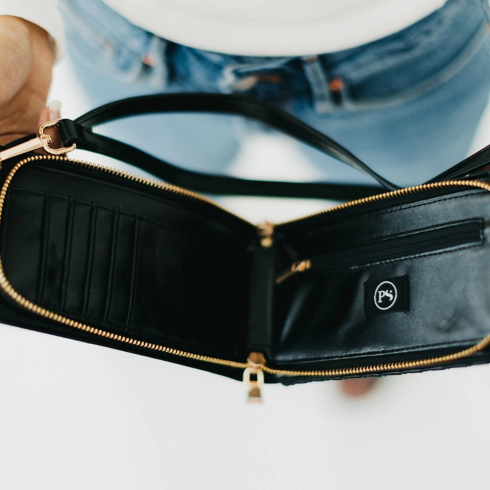 Black leather wallet with gold zipper on a white surface