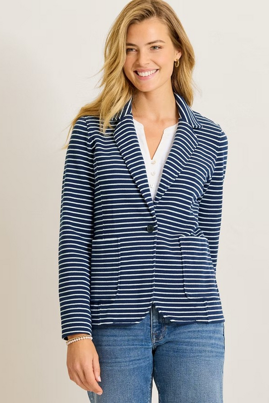 Woman wearing a blue and white striped blazer on a beige background