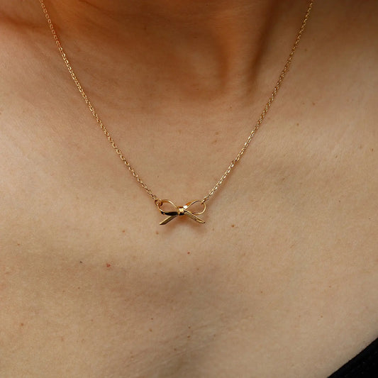 Gold necklace with a delicate pendant on a person's neck