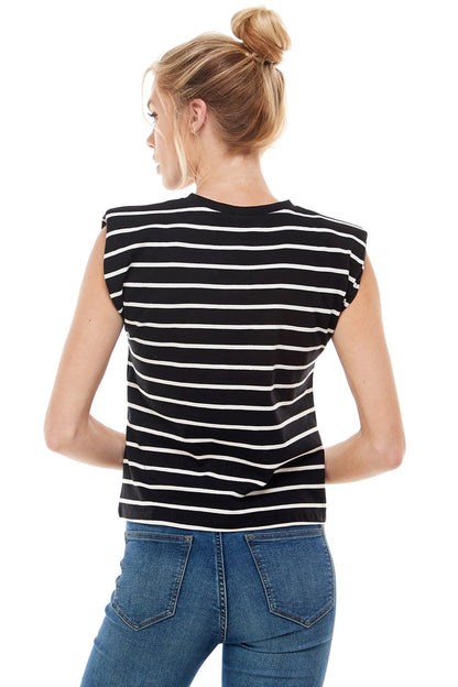 Woman wearing a black and white striped sleeveless top and blue jeans on a white background
