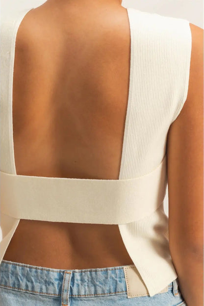 Beige sleeveless top with open back worn by a person on a white background