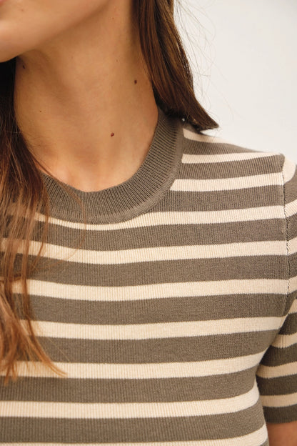 Close-up of a person wearing a short-sleeve ribbed knit top with horizontal taupe and cream stripes.