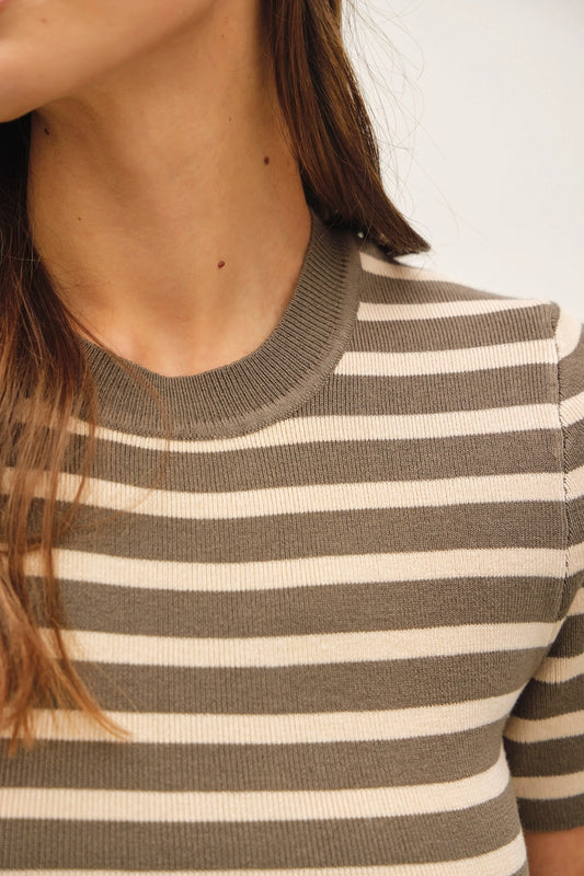 Close-up of a person wearing a short-sleeve ribbed knit top with horizontal taupe and cream stripes.