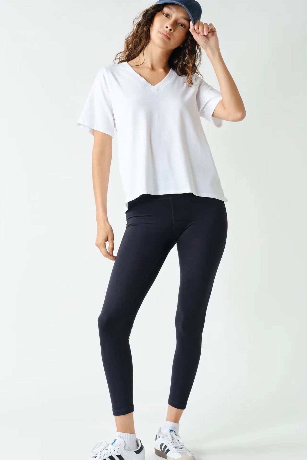 woman in white tee, hat and leggings