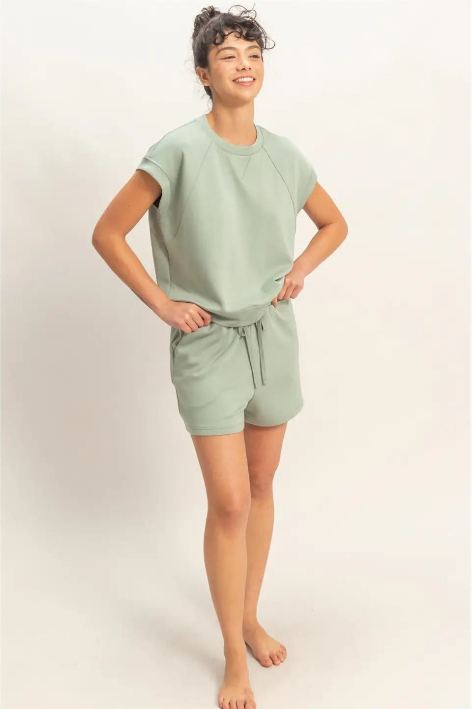 Person wearing a light green outfit on a plain background