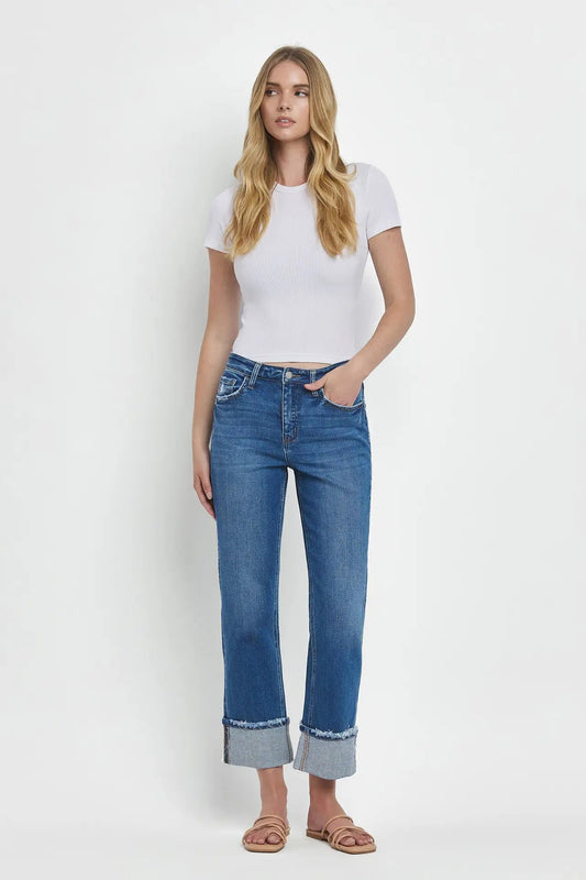 Woman wearing a white t-shirt and blue jeans on a white background