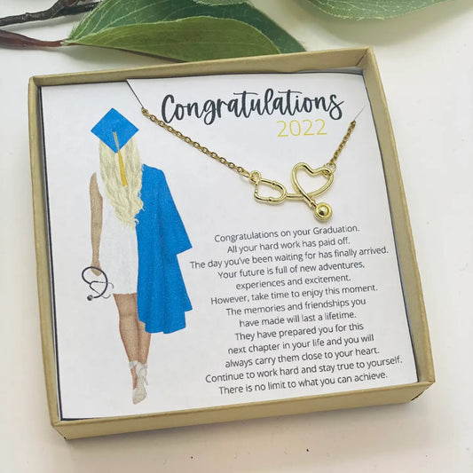Graduation-themed necklace with a card in a box, featuring text and illustrations of a graduate.