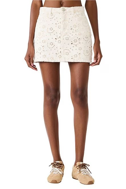 Person wearing a white skirt with gold speckles on a white background