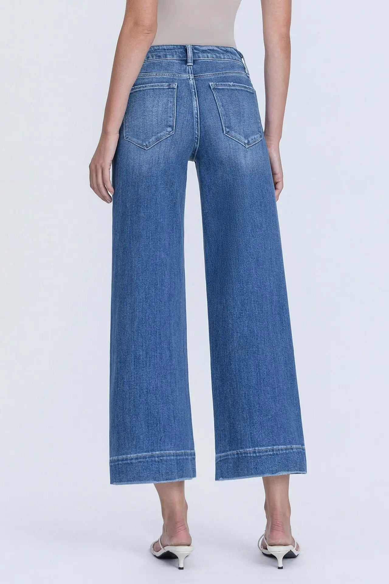 Blue jeans worn by a person on a white background