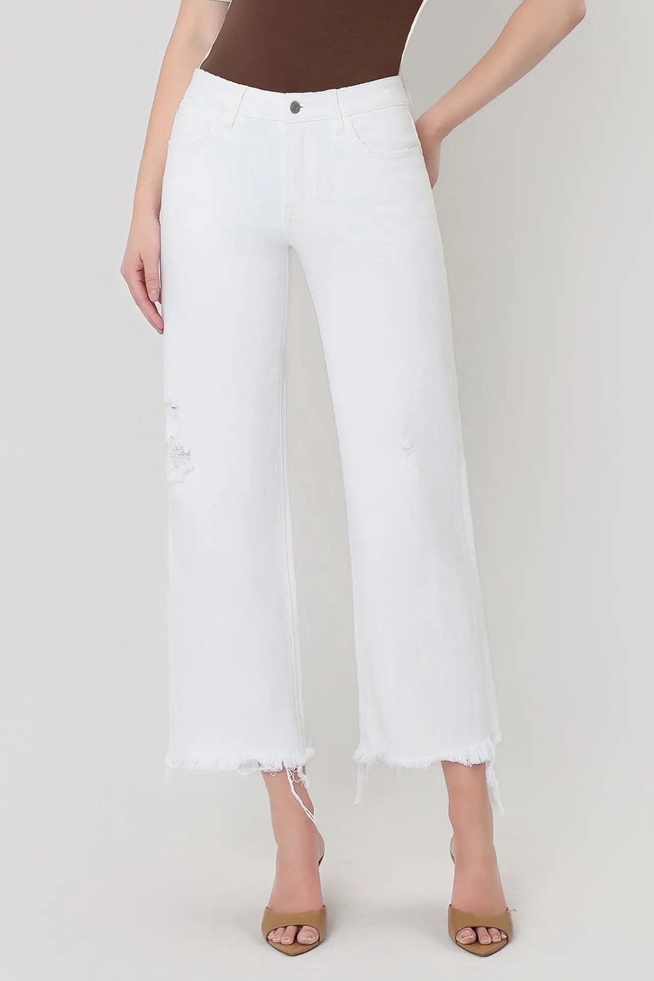 Person wearing white jeans on a plain background