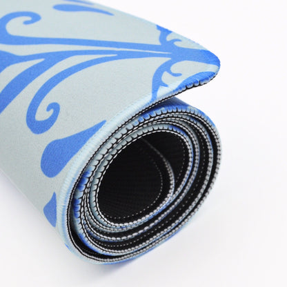 A rolled-up exercise or yoga mat with a light blue and blue patterned top surface and a black textured underside, shown on a white background.