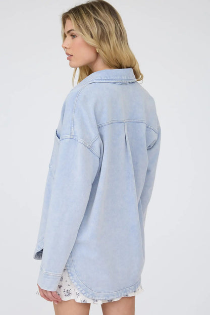 Woman wearing a light blue denim jacket on a white background