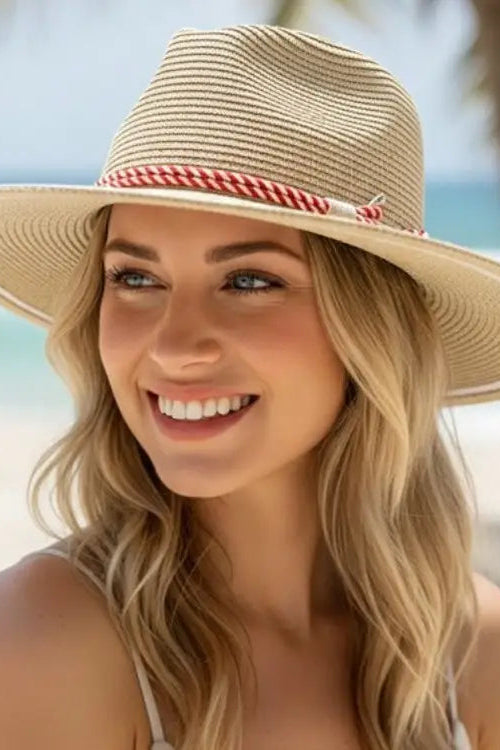 Woman wearing a straw hat with a checkered band on a beach