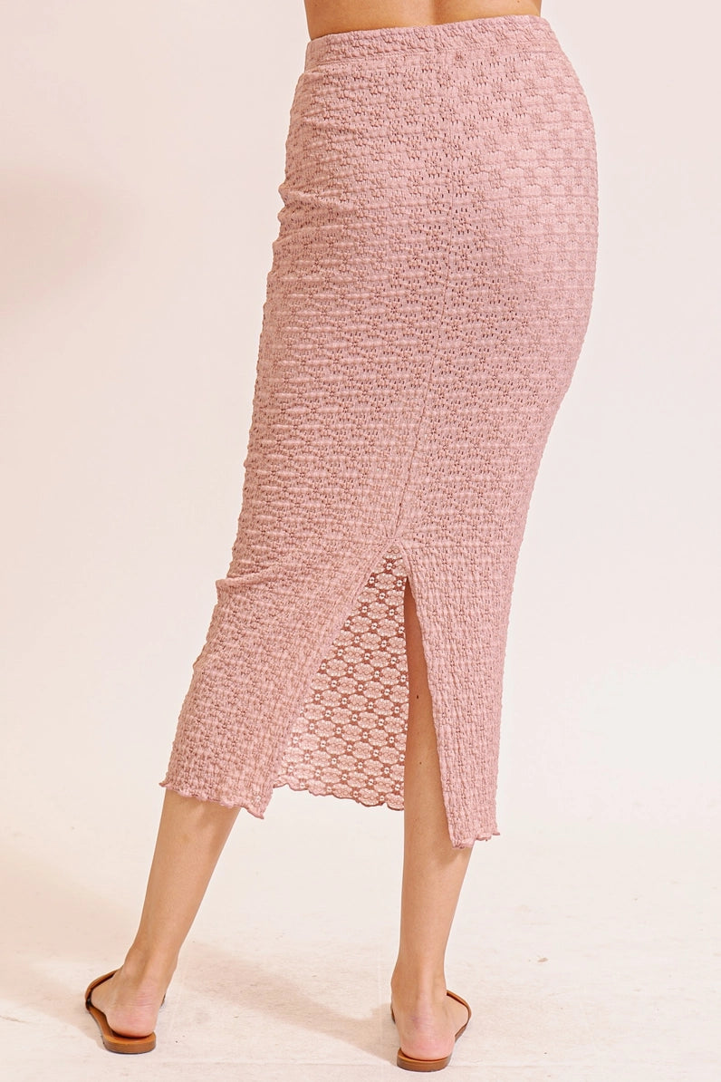 Pink textured skirt worn by a person on a beige background
