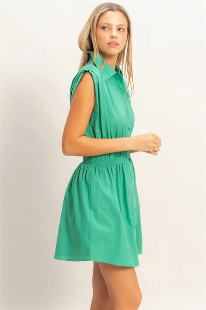 Woman wearing a green dress against a plain background