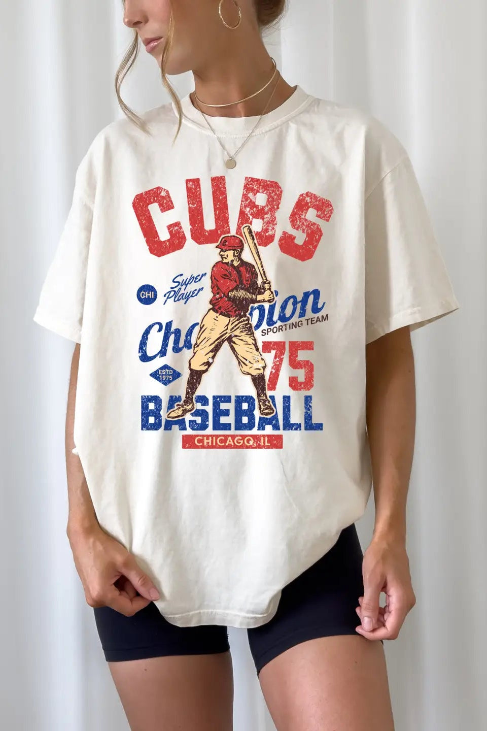 Person wearing a white t-shirt with Cubs baseball graphic design.