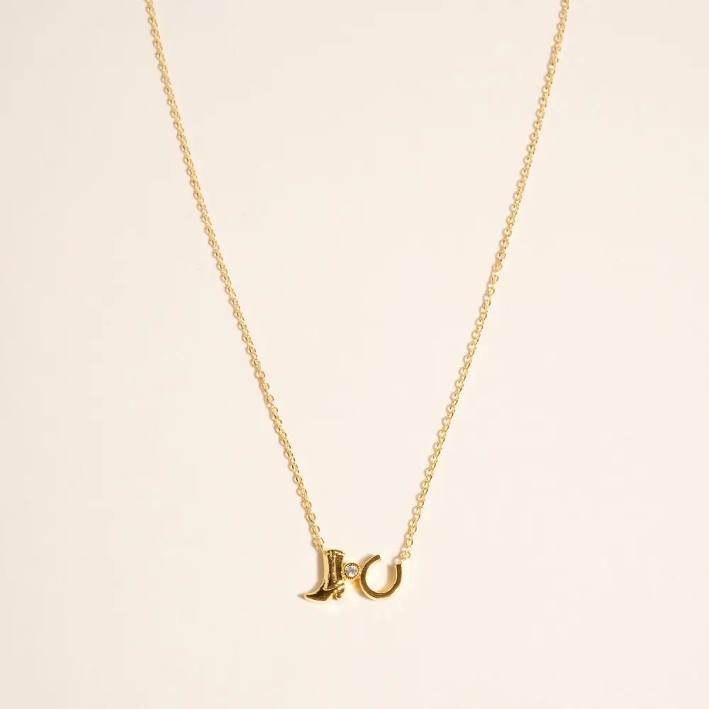 Gold necklace with a unique pendant on a beige background