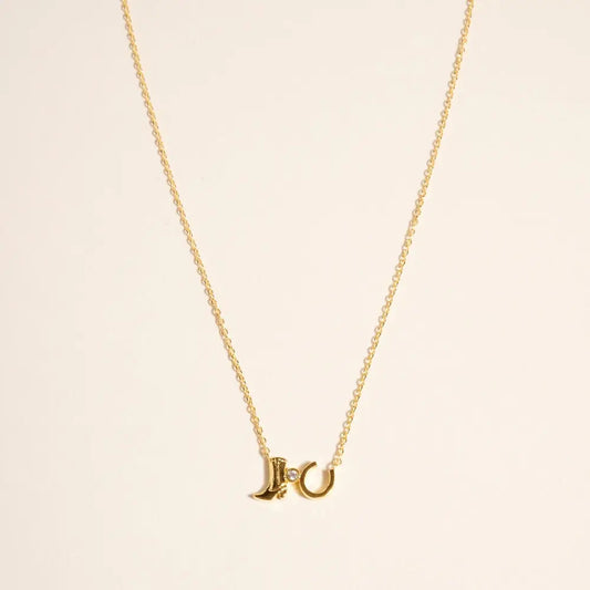 Gold necklace with a unique pendant on a beige background