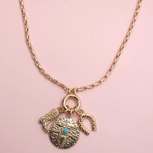Necklace with three charms on a pink background
