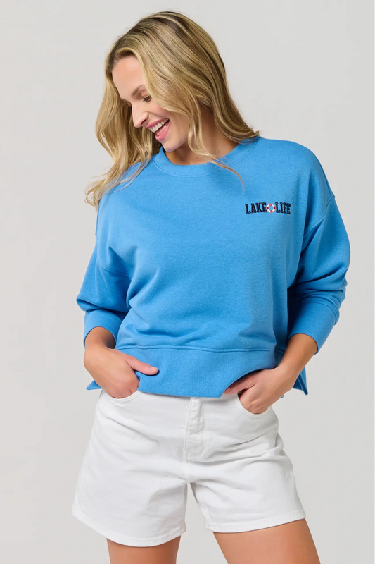 Woman wearing a blue sweatshirt with 'Lake Life' text on a plain background