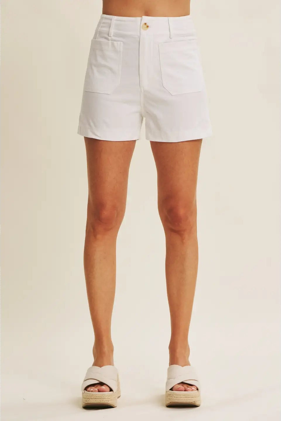 White shorts worn by a person on a plain background
