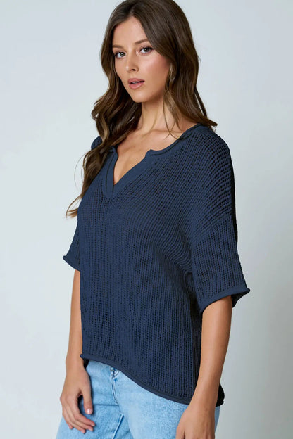 Woman wearing a blue knitted top against a plain background