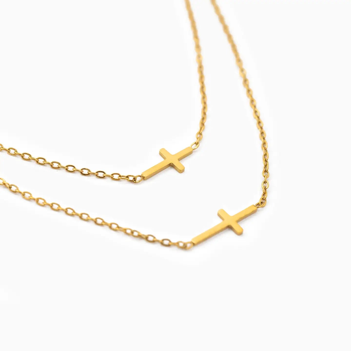 Gold cross necklace on a white background