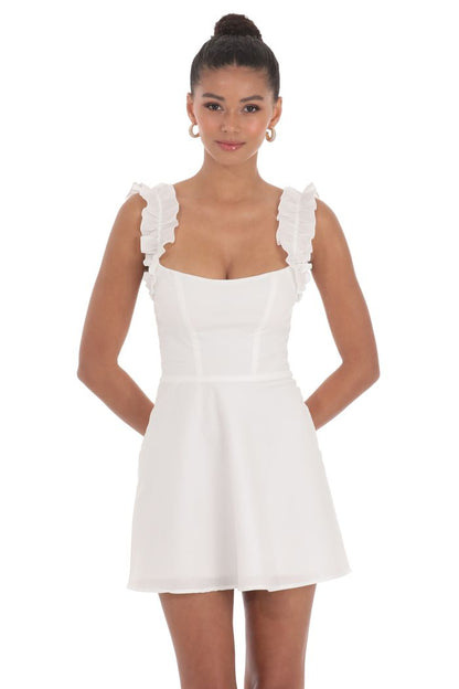 White dress with ruffled straps worn by a model on a white background