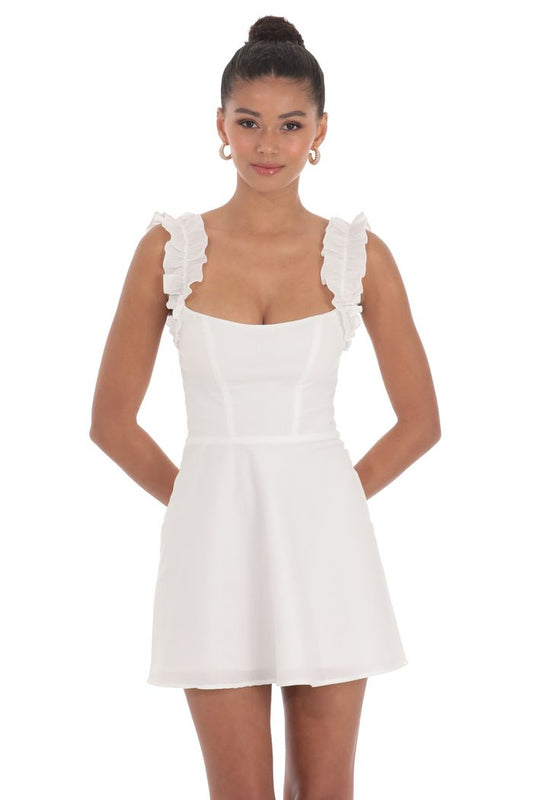 White dress with ruffled straps worn by a model on a white background