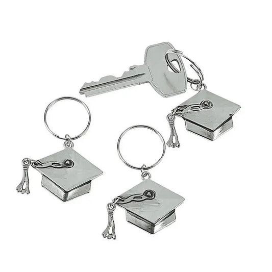 Set of silver keychains with graduation cap and tassel charms on a white background