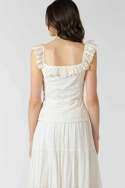 Woman wearing a white lace dress on a plain background