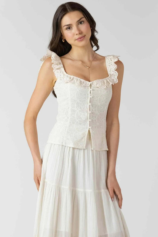 Woman wearing a white lace top and skirt set on a plain background