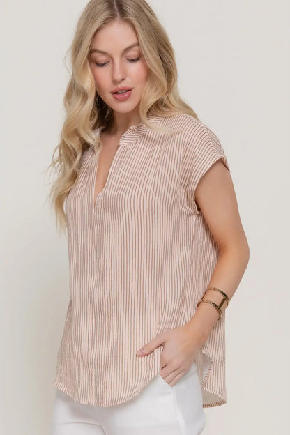 Woman wearing a striped shirt against a plain background