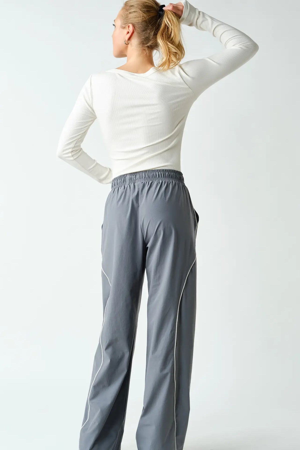 back view of woman in long sleeve tee and pants
