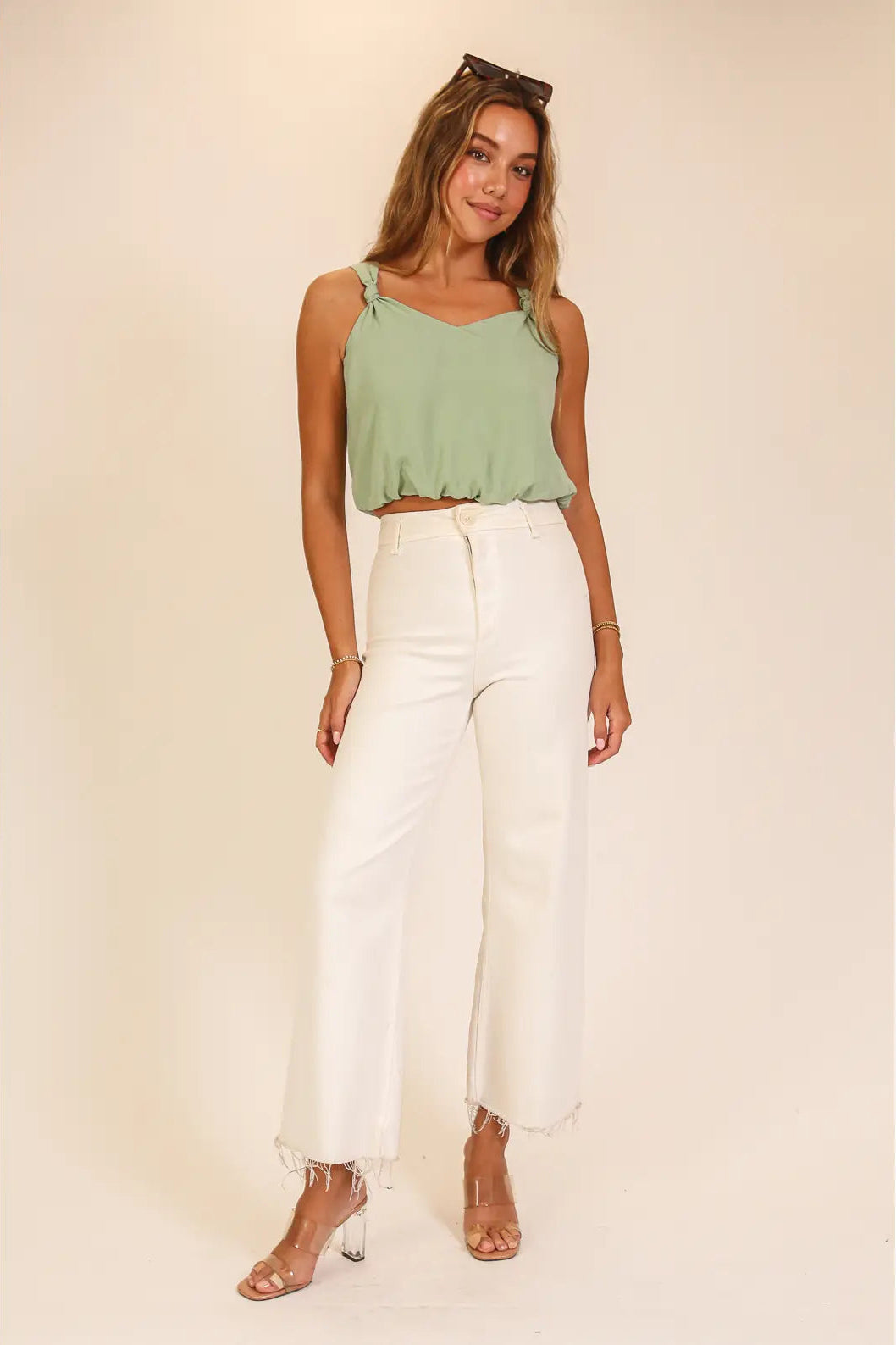 woman wearing green tank with white bottoms