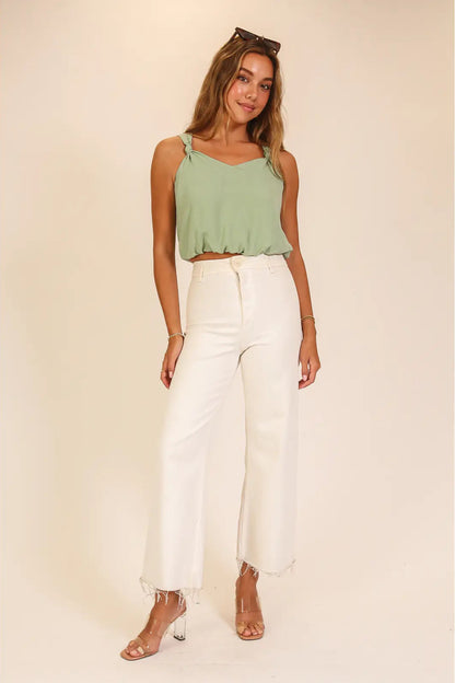woman wearing green tank with white bottoms