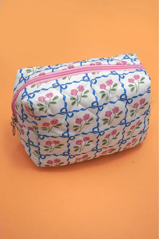 Small pouch with floral pattern and pink zipper on an orange background