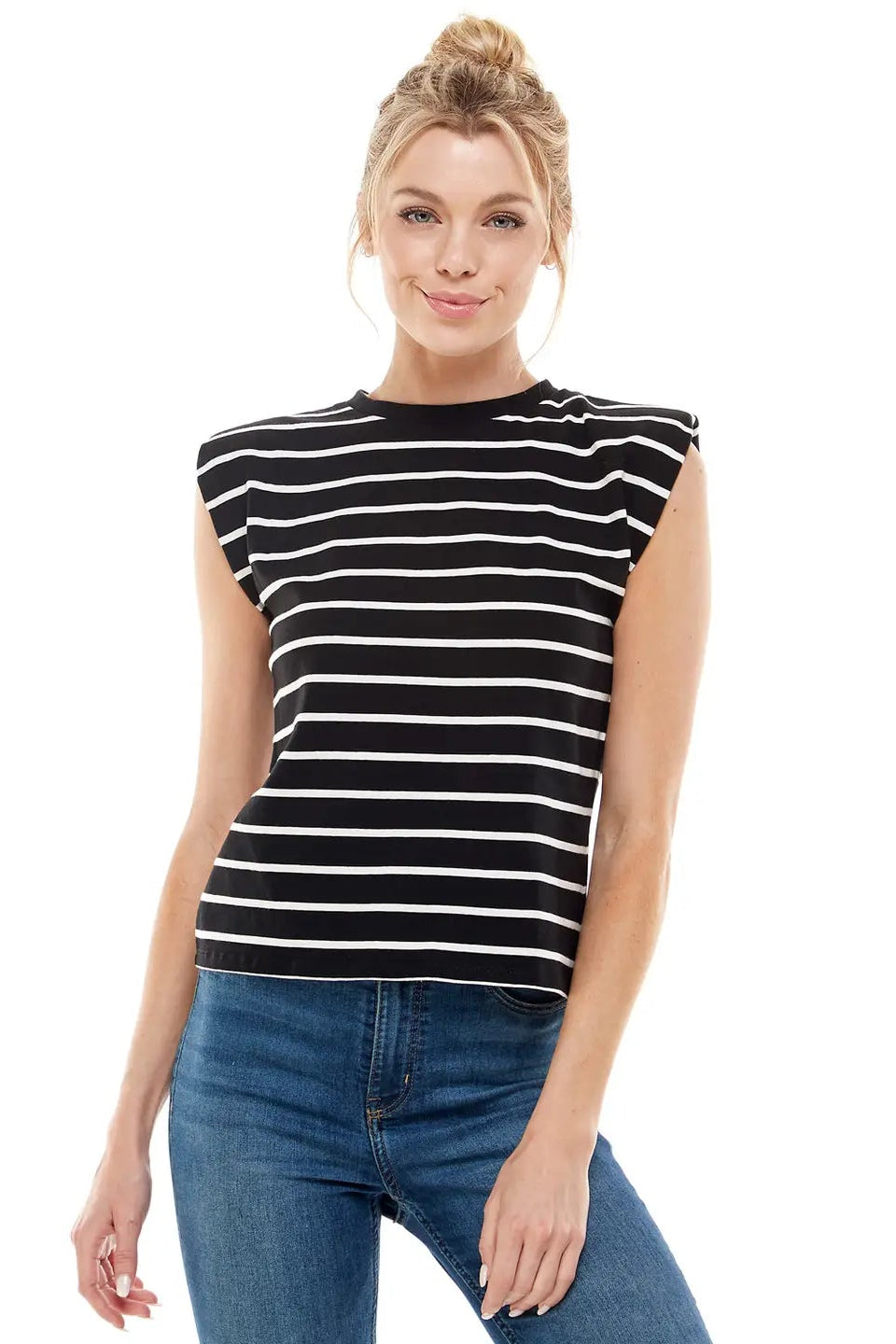 Woman wearing a black and white striped sleeveless top and blue jeans on a white background