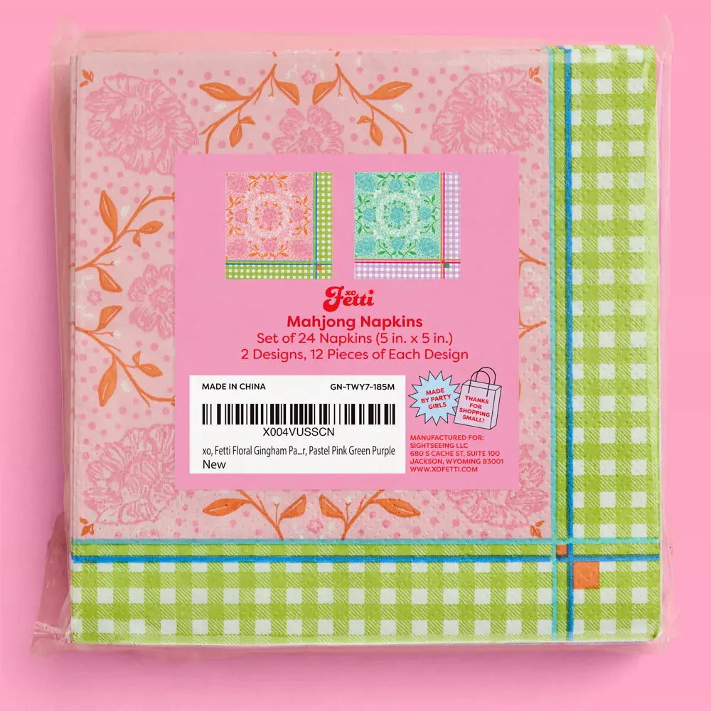 A packaged set of Fetti Mahjong Napkins in a pink plastic bag, featuring floral and gingham patterns in green, pink, orange, and blue, with a pink label in the center.