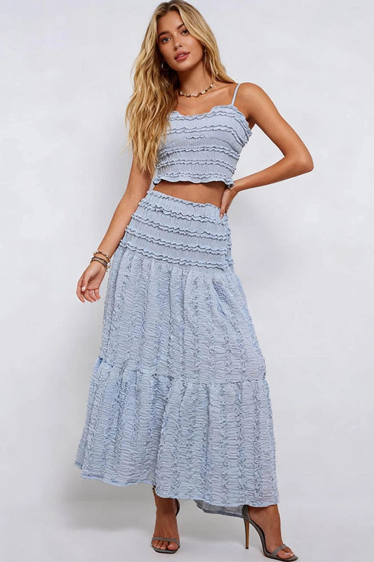 Woman wearing a light blue dress with ruffled layers on a white background