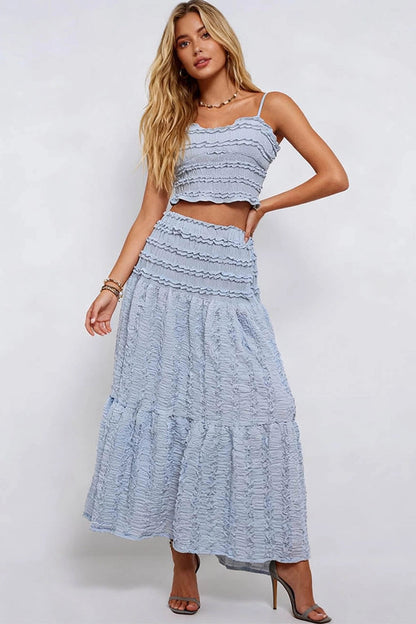 Woman wearing a light blue dress with ruffled layers on a white background