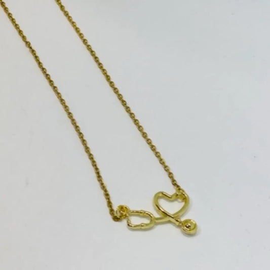 Gold necklace with a heart and infinity symbol pendant on a light gray background