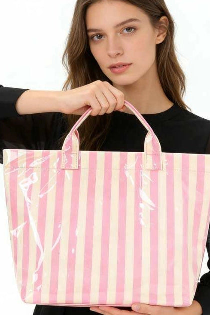 Woman holding a pink and white striped tote bag against a white background