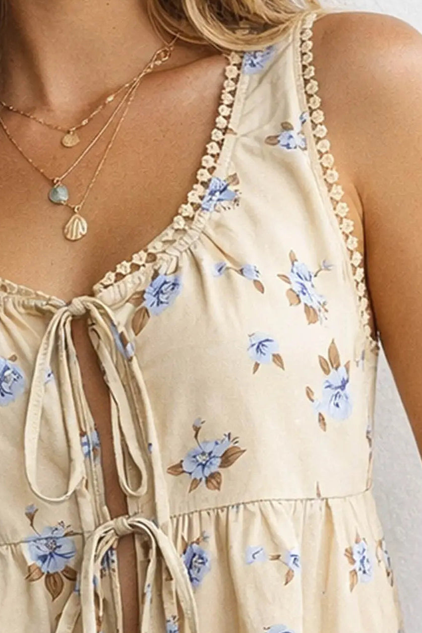 Beige floral dress with blue flowers and thin straps on a white background
