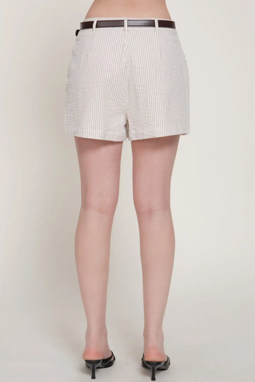 Person wearing a white and black checkered skirt on a plain background