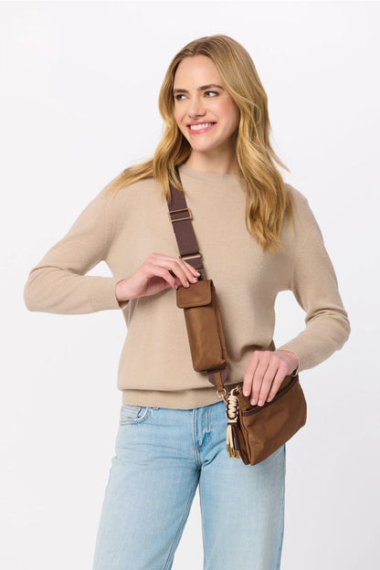 Woman holding a brown leather bag against a white background