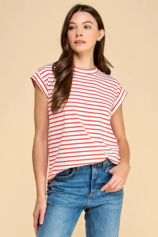 Woman wearing a red and white striped shirt and blue jeans on a beige background
